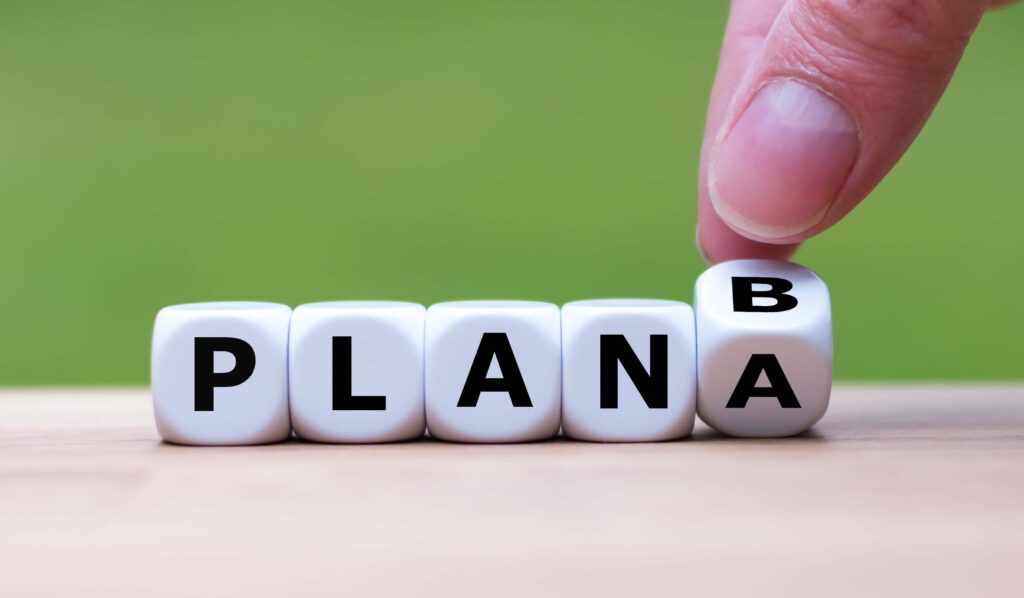 Time for Plan B. Hand is turning a dice and changes the word "Plan A" to "Plan B"