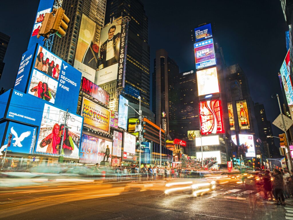 Times Square illuminated at night with yellow taxi cabs in traffic jam, advertising and billboards in background, Manhattan, New York, USA