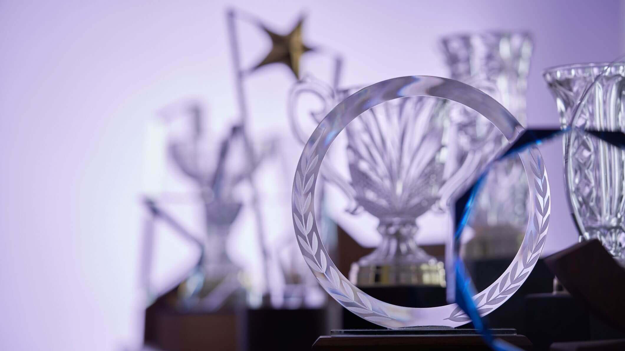 group of crystal trophies against purple background